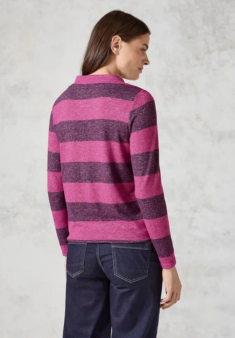 Frau mit gestreiftem Pullover in Pink und Lila, Rückenansicht.